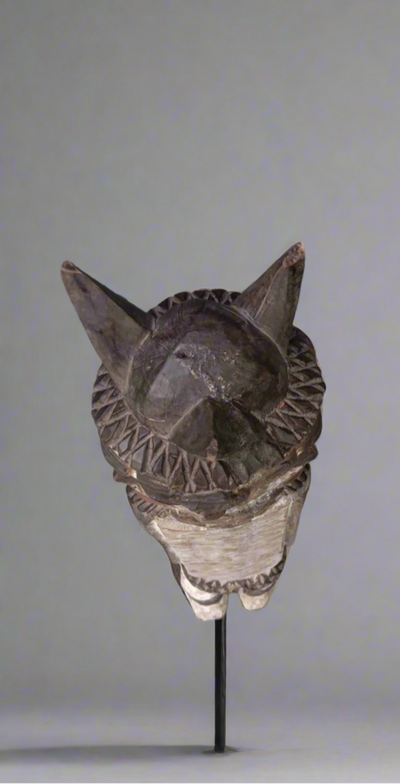 Decorative mask on a stand against a plain background
